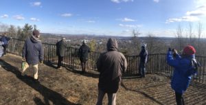 Group of people on a hill overlooking Boston in the distance