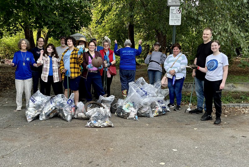 A group of people stand with the trash they cleaned up.